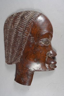 a wooden sculpture of a woman ' s head on the wall
