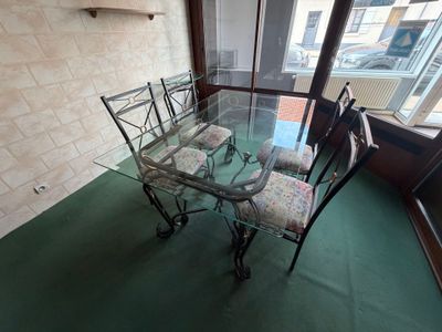 une table et des chaises en verre dans une pièce dotée d'une grande fenêtre