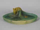 a small figurine of a cat on a plate