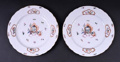 deux assiettes blanches ornées de motifs colorés, posées sur une surface noire