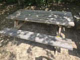 a wooden picnic table in the middle of the woods
