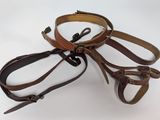 three belts that are tied together on a white surface
