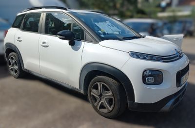 a picture of a small white car parked in a parking lot