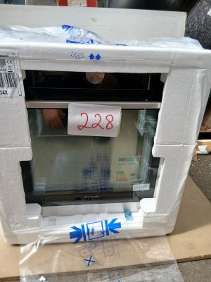 un micro-ondes blanc posé sur un carton sur lequel est accrochée une étiquette de prix