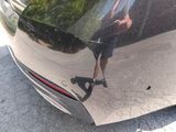 a reflection of a man on the rear of a car