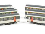 two train cars sitting side by side on a white surface