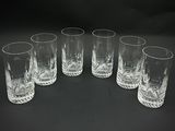 six glasses are lined up in a circle on a black surface