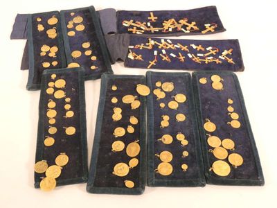 plusieurs morceaux de tissu sur lesquels sont posées des pièces d'or, posés sur une table