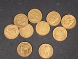 quelques pièces d'or posées sur une surface noire, en petit nombre
