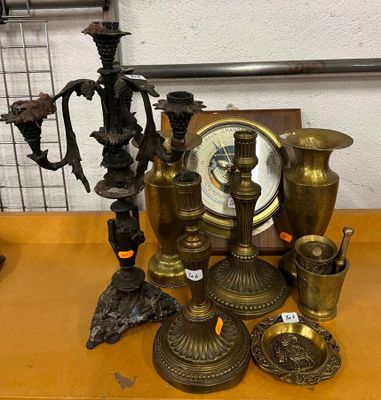 de nombreux objets en laiton posés sur une table où se trouve une horloge