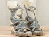 pair of women ' s wedged sandals on a wooden surface