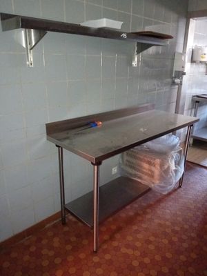 a kitchen with a stainless steel table and shelves