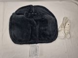 un sac noir auquel est attaché un cordon, posé sur un lit