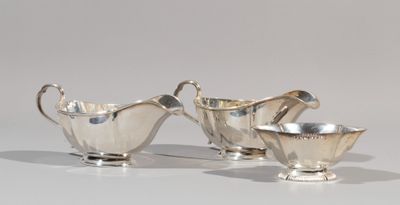 three pieces of silverware sitting on top of a white surface