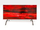 red abstract painting on a metal stand on a white background