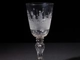 a wine glass with a pattern on it sitting on a table