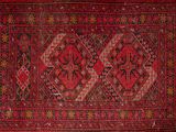 a red and black rug with a design on it