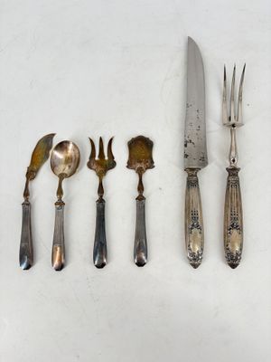five forks, a knife, and a spoon on a table