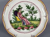 une image représentant une assiette décorative sur laquelle figure une femme assise sur une chaise
