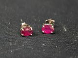 a pair of pink stone stud earrings on a black surface