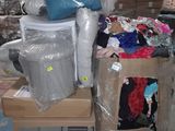 a pile of clothes and other items on a pallet in a warehouse