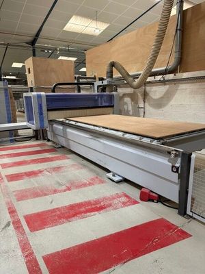 a machine that is cutting a piece of wood in a factory