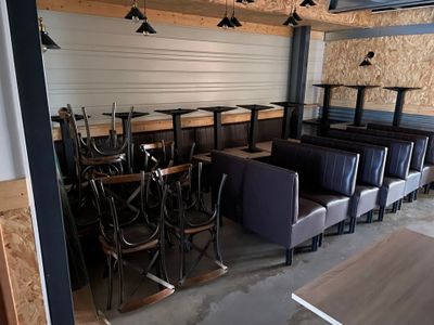 Des tables et des chaises sont alignées dans une pièce aux murs lambrissés.