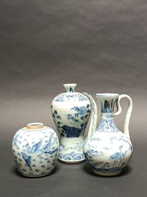 three blue and white vases and a vase on a table
