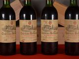 three bottles of red wine are lined up on a table