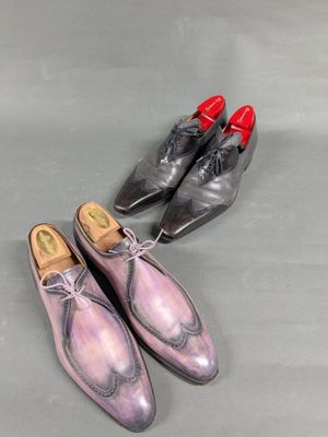 two pairs of men ' s shoes sitting next to each other on a table