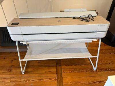 an image of a printer on a stand on a wooden floor
