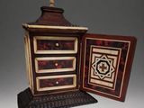 a small wooden box with a drawer inside of it