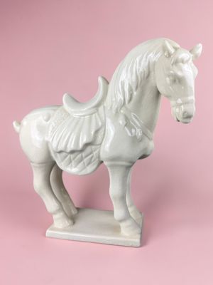 a white horse statue on a pink background