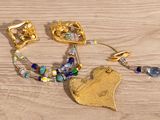 a gold bracelet with a heart and a heart shaped broocher on it