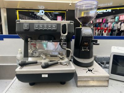 une machine à café posée sur un plan de travail, à côté d'un micro-ondes