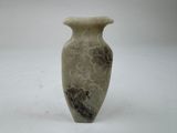un vase blanc orné d'un motif posé sur une table