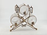 three glass jars on a metal stand with a white background