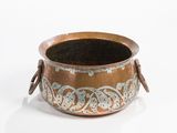 a small copper pot with a handle on a white surface
