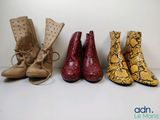 trois paires de bottes pour femmes sont alignées contre un mur blanc