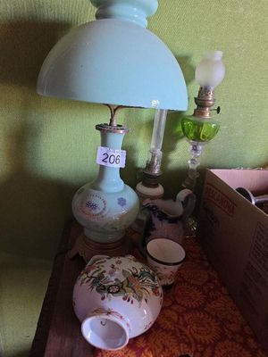 une table sur laquelle se trouvent une lampe, une théière, une tasse à thé et une boîte