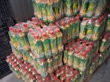 many bottles of soda sitting on a pallet in a warehouse