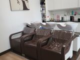three brown leather chairs in a room with a painting on the wall