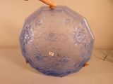 une main tenant un vase bleu posé sur une table
