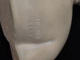 a close up of a white vase on a black surface