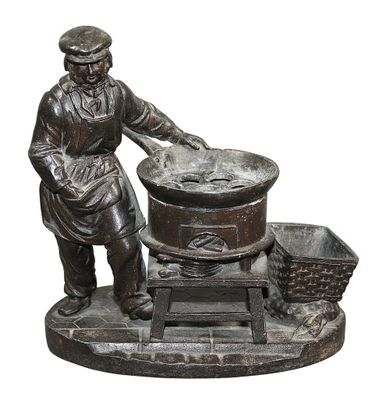 PORTE-STYLO (?) en régule patiné figurant un cuisinier à cot…