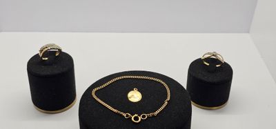 un gros plan sur un collier, un bracelet et une bague posés sur une table