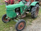 un tracteur vert qui est garé dans l'herbe