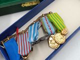 three medals in a blue box on a white table