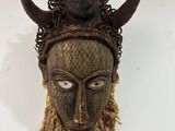 une image représentant un masque en bois muni de cornes sur la tête