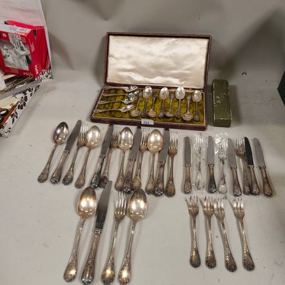 a lot of silver spoons and forks in a box